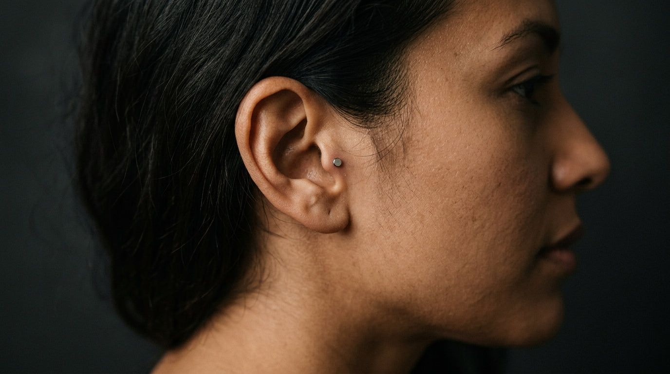 Piercing tragus en titane porté sur une oreille, vue de profil